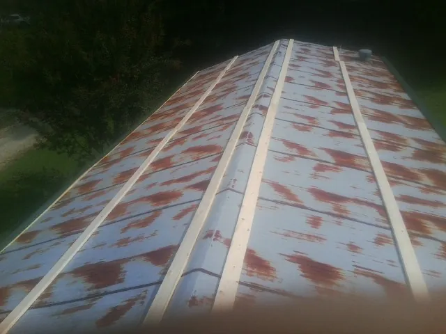 Rusted metal roof panels with new wood purlins before replacement — Storm Damage Roof Repair in Olney by Roofing Brothers